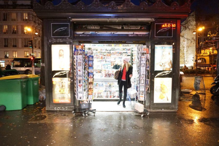 french news stand in paris magazines at night